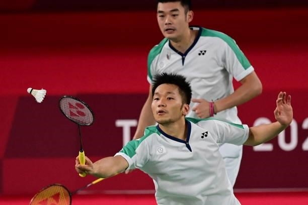 Taiwan's Lee Yang hits a shot next to Taiwan's Wang Chi-lin in their men's doubles badminton final match against China's Li Junhui and China's Liu...