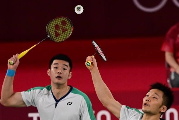 Taiwan's Wang Chi-lin and Taiwan's Lee Yang reach for a shot in their men's doubles badminton final match against China's Li Junhui and China's Liu...