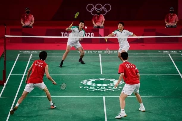 Taiwan's Wang Chi-lin hits a shot next to Taiwan's Lee Yang in their men's doubles badminton final match against China's Li Junhui and China's Liu...