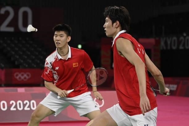 China's Li Junhui hits a shot next to China's Liu Yuchen in their men's doubles badminton final match against Taiwan's Wang Chi-lin and Taiwan's Lee...