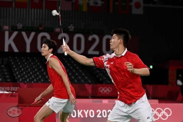 China's Liu Yuchen hits a shot next to China's Li Junhui in their men's doubles badminton final match against Taiwan's Wang Chi-lin and Taiwan's Lee...