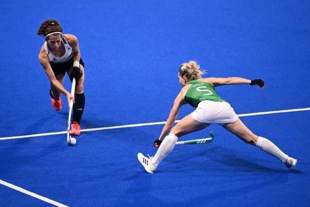 Britain's Anna-Frances Toman is tackled by Ireland's Nicola Daly during their women's pool A match of the Tokyo 2020 Olympic Games field hockey...