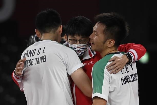 Taiwan's Lee Yang and Taiwan's Wang Chi-lin celebrate with a coach after winning their men's doubles badminton final match against China's Li Junhui...