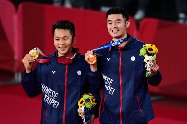 Taiwan's Lee Yang and Taiwan's Wang Chi-lin pose with their men's doubles badminton gold medals at a ceremony during the Tokyo 2020 Olympic Games at...