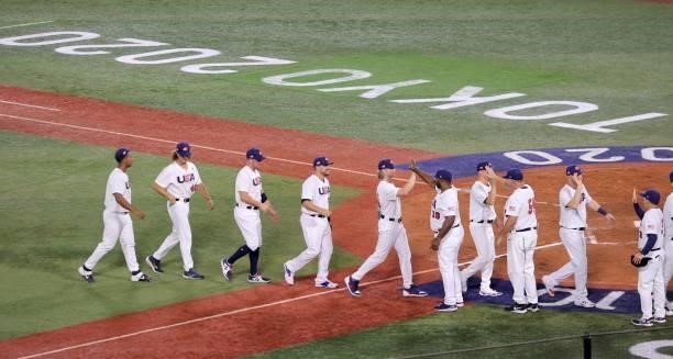S baseball players and coaches celebrate their victory during the Tokyo 2020 Olympic Games baseball opening round group B game between South Korea...