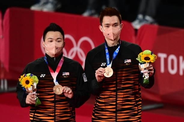 Malaysia's Aaron Chia and Malaysia's Soh Wooi Yik pose with their men's doubles badminton bronze medals at a ceremony during the Tokyo 2020 Olympic...
