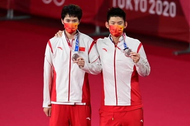 China's Liu Yuchen and China's Li Junhui pose with their men's doubles badminton silver medals at a ceremony during the Tokyo 2020 Olympic Games at...
