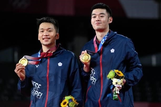 Taiwan's Lee Yang and Taiwan's Wang Chi-lin pose with their men's doubles badminton gold medals at a ceremony during the Tokyo 2020 Olympic Games at...