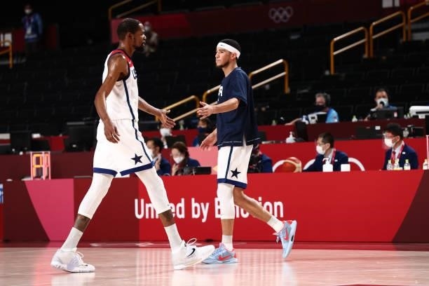 Kevin Durant of the USA Men's National Team high fives Devin Booker of the USA Men's National Team during the 2020 Tokyo Olympics on July 31, 2021 at...