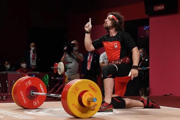 Canada's Boady Robert Santavy gestures as he competes in the men's 96kg weightlifting competition during the Tokyo 2020 Olympic Games at the Tokyo...