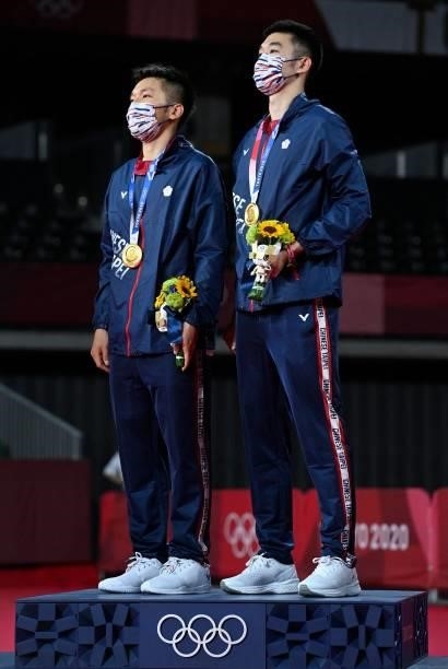 Taiwan's Lee Yang and Taiwan's Wang Chi-lin stand on the podium with their men's doubles badminton gold medals at a ceremony during the Tokyo 2020...
