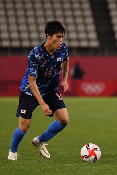 Takehiro Tomiyasu of Japan keeps the ball during the Men's Quarter Final match on day eight of the Tokyo 2020 Olympic Games at Kashima Stadium on...
