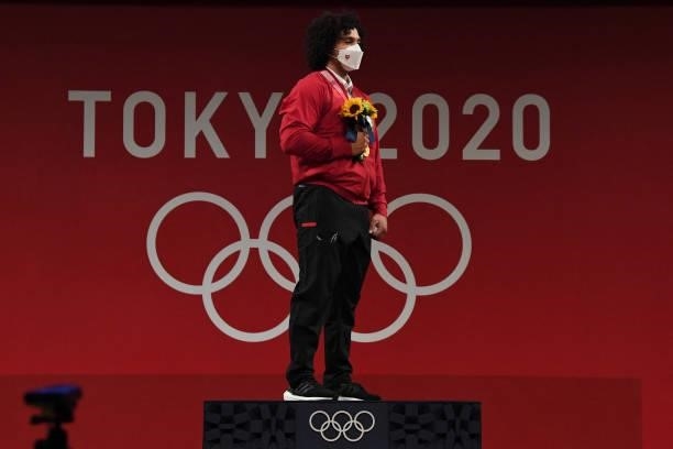 Gold medallist Qatar's Fares Ibrahim E H Elbakh poses on the podium for the victory ceremony of the men's 96kg weightlifting competition during the...