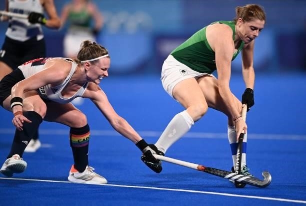 Britain's Hollie Pearne-Webb and Ireland's Kathryn Mullan vie for the ball during their women's pool A match of the Tokyo 2020 Olympic Games field...