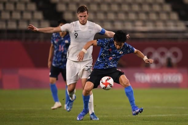 Wataru Endo of Japan keeps the ball under the pressure from Chris Wood of New Zealand during the Men's Quarter Final match on day eight of the Tokyo...