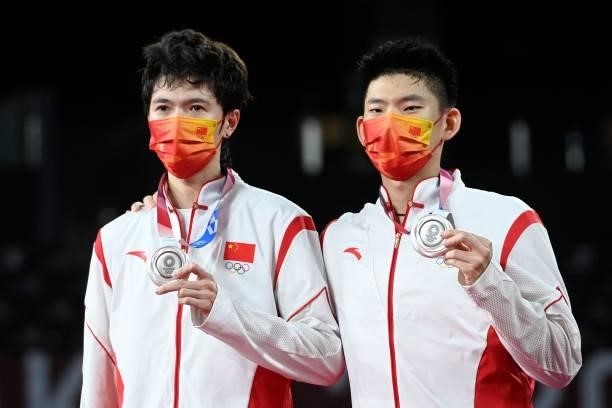China's Liu Yuchen and China's Li Junhui pose with their men's doubles badminton silver medals at a ceremony during the Tokyo 2020 Olympic Games at...