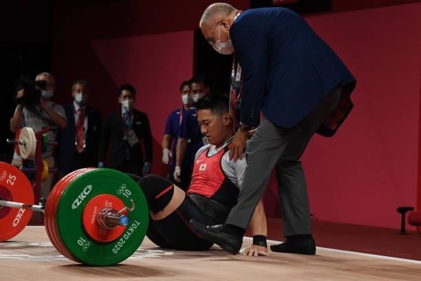 Japan's Toshiki Yamamoto receives medical attention during the men's 96kg weightlifting competition during the Tokyo 2020 Olympic Games at the Tokyo...