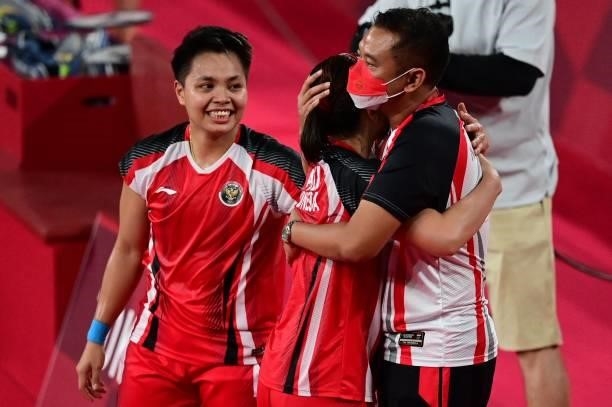 Indonesia's Greysia Polii and Indonesia's Apriyani Rahayu celebrate with a coach after winning their women's doubles badminton semi-final match...
