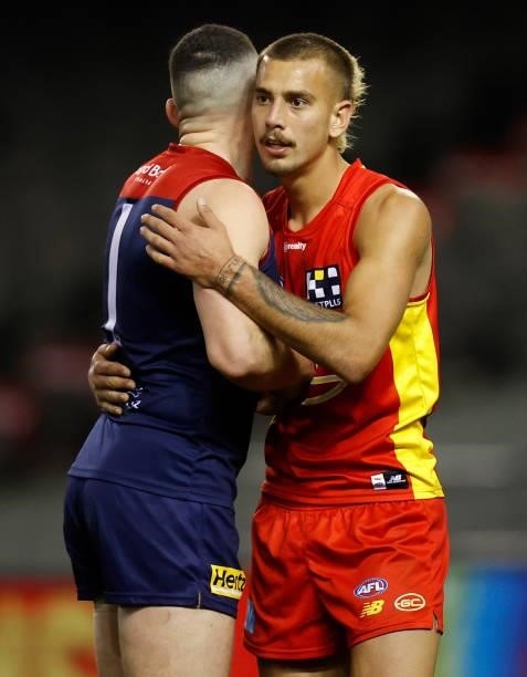 Steven May of the Demons and Joel Jeffrey of the Suns embrace after the 2021 AFL Round 20 match between the Gold Coast Suns and the Melbourne Demons...