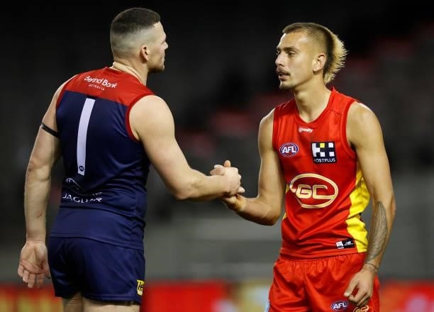 Steven May of the Demons and Joel Jeffrey of the Suns embrace after the 2021 AFL Round 20 match between the Gold Coast Suns and the Melbourne Demons...