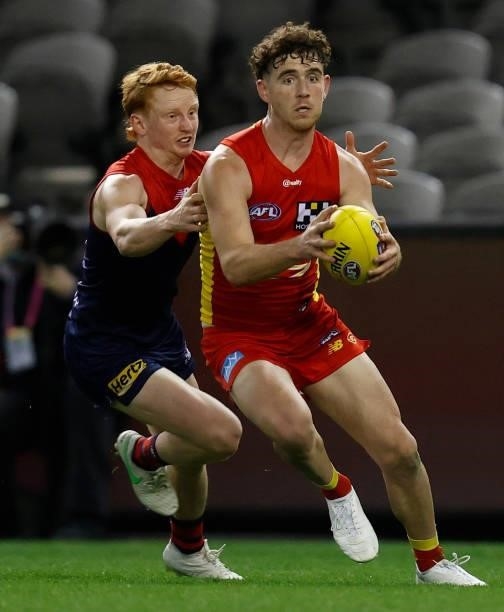 Sam Flanders of the Suns is tackled by Jake Bowey of the Demons during the 2021 AFL Round 20 match between the Gold Coast Suns and the Melbourne...