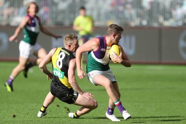 Luke Ryan of the Dockers evades Jack Riewoldt of the Tigers during the 2021 AFL Round 20 match between the Fremantle Dockers and the Richmond Tigers...