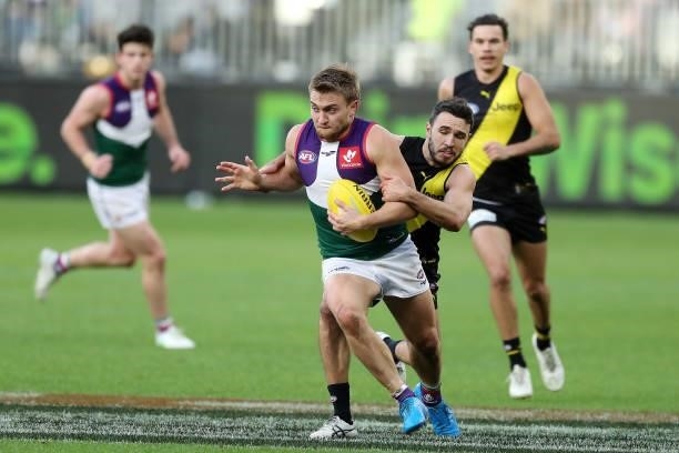 Mitch Crowden of the Dockers is tackled by Shane Edwards of the Tigers during the 2021 AFL Round 20 match between the Fremantle Dockers and the...