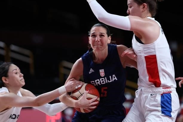Serbia's Sonja Vasic fights for the ball with South Korean players in the women's preliminary round group A basketball match between South Korea and...