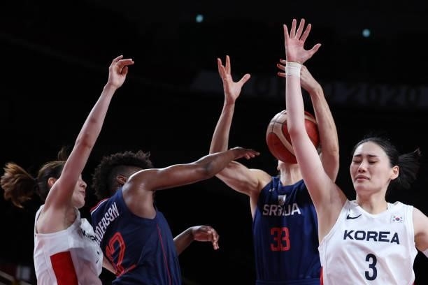 South Korea's Kang Leeseul fights for the ball with Serbia's Tina Krajisnik and Yvonne Anderson in the women's preliminary round group A basketball...