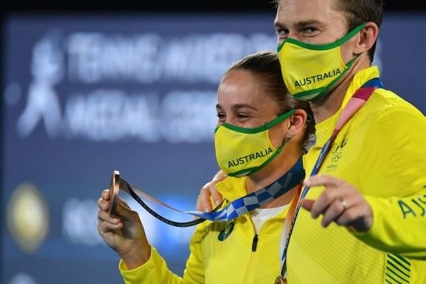 Bronze medallists Australia's Ashleigh Barty and Australia's John Peers pose with their medal the Tokyo 2020 Olympic mixed doubles tennis medal...