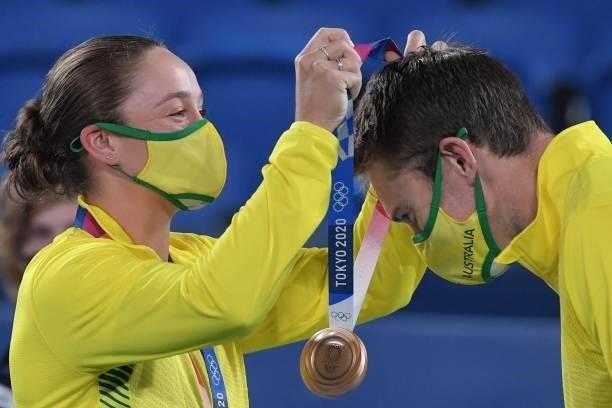 Bronze medallists Australia's Ashleigh Barty and Australia's John Peers put on their respective during medal the Tokyo 2020 Olympic mixed doubles...