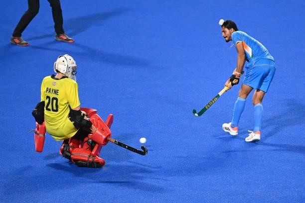 India's Dilpreet Singh strikes the ball to score past Britain's goalkeeper Oliver Payne during their men's quarter-final match of the Tokyo 2020...