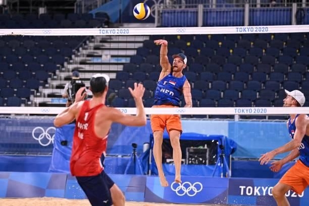 Netherlands' Alexander Brouwer plays a shot as Norway's Anders Berntsen Mol watches in their men's beach volleyball round of 16 match between Norway...