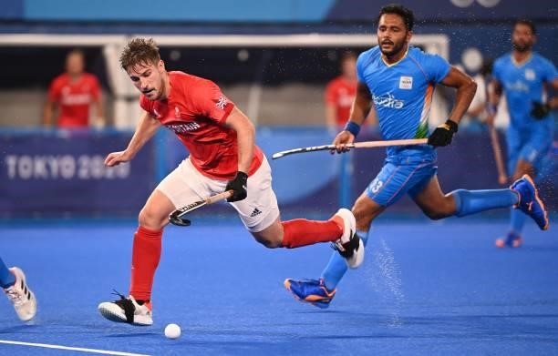 Britain's Liam Paul Ansell carries the ball past India's Harmanpreet Singh during their men's quarter-final match of the Tokyo 2020 Olympic Games...