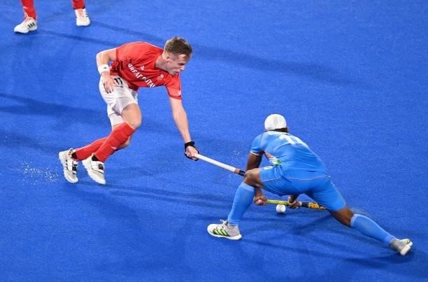 Britain's Ian Martin Sloan and India's Simranjeet Singh vie for the ball during their men's quarter-final match of the Tokyo 2020 Olympic Games field...