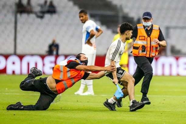Illustration a steward catches a streaker on the field during the friendly football match between Marseille and Villarreal at Orange Velodrome on...