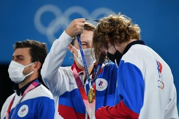 Gold medallists Russia's Anastasia Pavlyuchenkova and Russia's Andrey Rublev put on their respective medal during the Tokyo 2020 Olympic mixed...