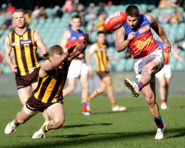 James Worpel of the Hawks tries smother the kick of Dayne Zorko of the Lions during the 2021 AFL Round 20 match between the Hawthorn Hawks and the...
