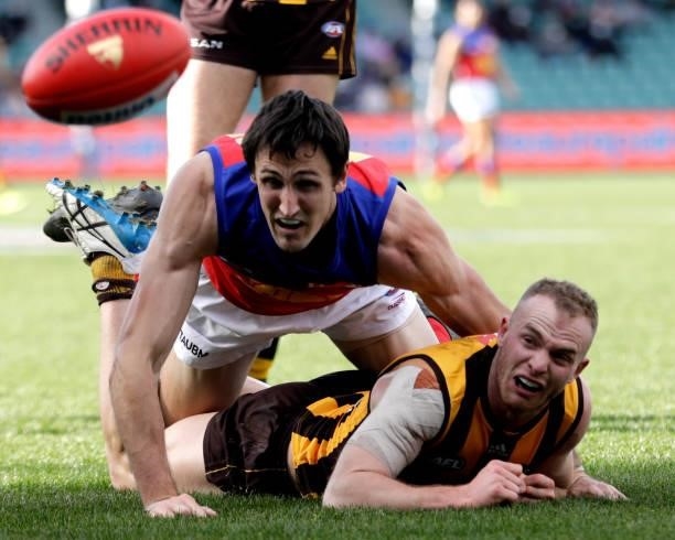 Tom Mitchell of the Hawks and Oscar McInerney of the Lions compete for the ball during the 2021 AFL Round 20 match between the Hawthorn Hawks and the...