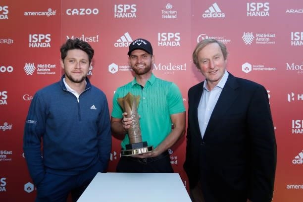 Daniel Gavins of England poses with the trophy and Niall Horan following his victory during the final round of the ISPS HANDA World Invitational at...
