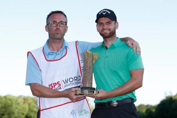 Daniel Gavins of England poses with his caddie and the trophy following his victory during the final round of the ISPS HANDA World Invitational at...