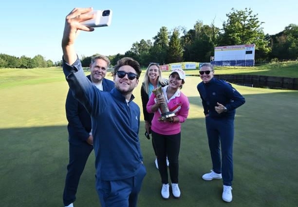 Parjaree Anannarukarn of Thailand has a selfie taken with the ISPS HANDA trophy alongside the Modest Golf team including music artist Niall Horan...