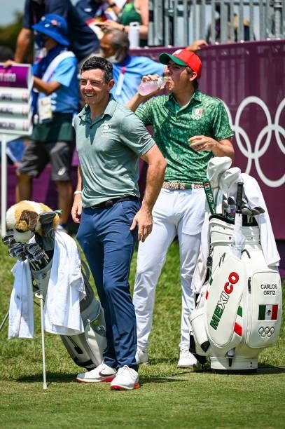 Rory McIlroy of Team Ireland smiles with Carlos Ortiz of Team Mexico on the first tee during the final round of Mens Individual Stroke Play Golf on...
