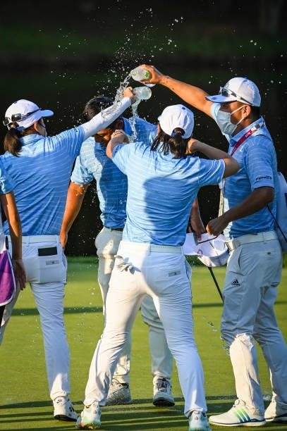 Pan of Team Chinese Taipei celebrates with teammates who spray him with water after winning the bronze medal on the 18th hole during a playoff in the...