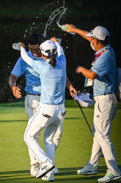 Pan of Team Chinese Taipei celebrates with teammates who spray him with water after winning the bronze medal on the 18th hole during a playoff in the...