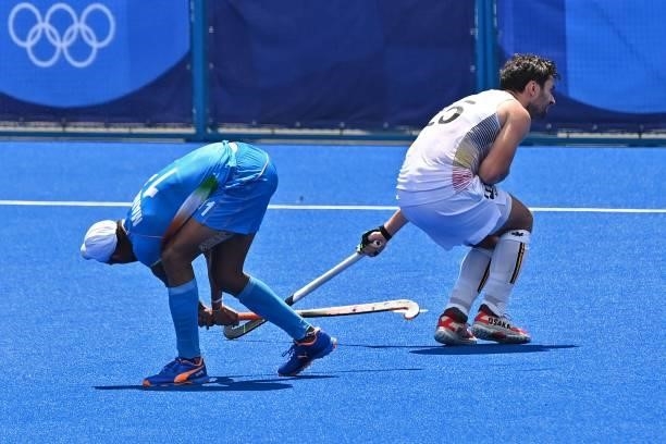 India's Mandeep Singh strikes the ball next to Belgium's Loick Fanny Luypaert during their men's semi-final match of the Tokyo 2020 Olympic Games...