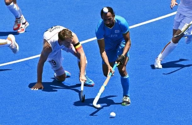India's Hardik Singh dribbles the ball past Belgium's Felix Veronique Denayer during their men's semi-final match of the Tokyo 2020 Olympic Games...