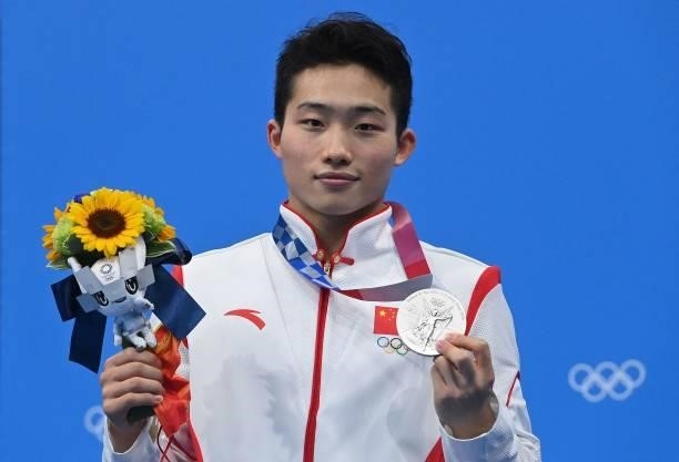 Silver medallist China's Wang Zongyuan poses with their medal on the podium after the men's 3m springboard diving final event during the Tokyo 2020...