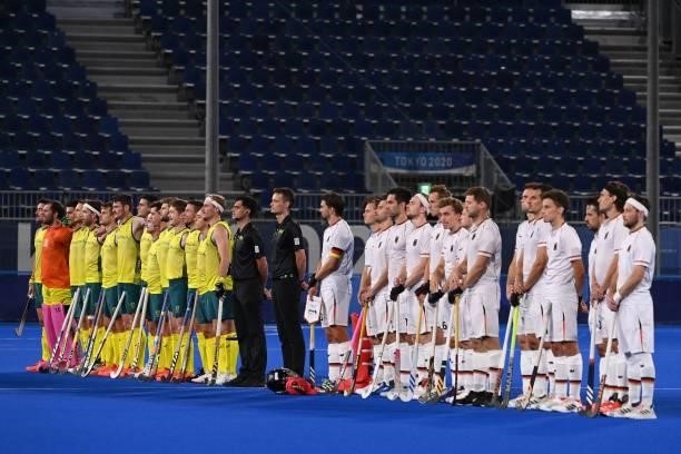 Players of Australia and Germany and umpires listen to the national anthems before their men's semi-final match of the Tokyo 2020 Olympic Games field...