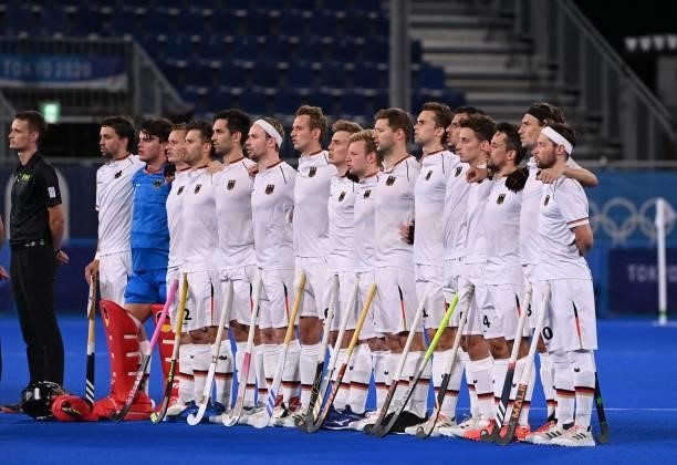 Players of Germany listen to the national anthems before the men's semi-final match of the Tokyo 2020 Olympic Games field hockey competition against...